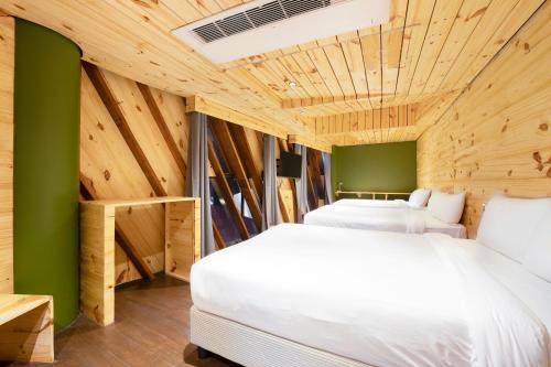 zwei Betten in einem Zimmer mit grünen Wänden und Holzdecken in der Unterkunft G1 Lodge Design Hotel in Baguio City