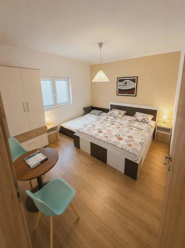 a bedroom with a bed and a table and a chair at 3 Stars Apartments in Prilep