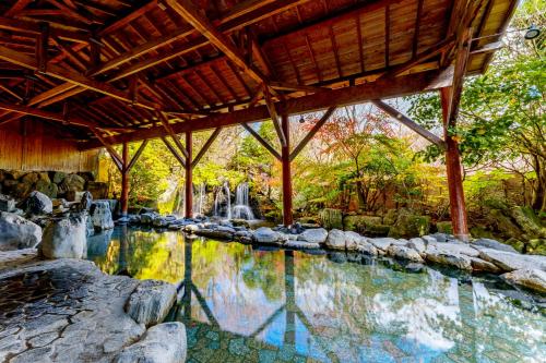 a swimming pool in a resort with a waterfall at Hotel Epinard Nasu in Nasu