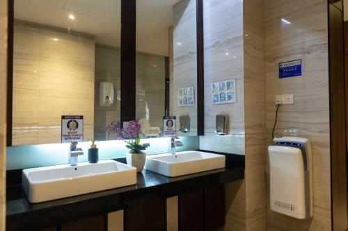 a bathroom with two sinks and a mirror at Meritin Hotel in Kuching
