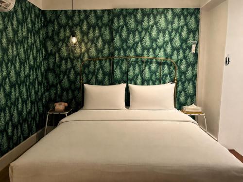 a bedroom with a bed with a green wallpaper at Hotel Le'O in Seoul