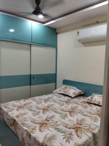a bedroom with a bed and blue cabinets at Venya Vihar Vizag MVP AC Deluxe 1 BHK Studio Apartment in Visakhapatnam