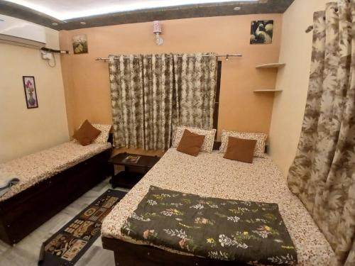 a room with two beds and a window at KHS ROOMs near ghat and temples in Varanasi