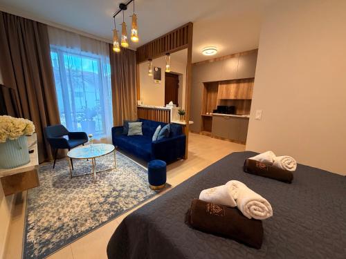 a bedroom with two beds and a living room at CasaBlanca vendégház in Abádszalók