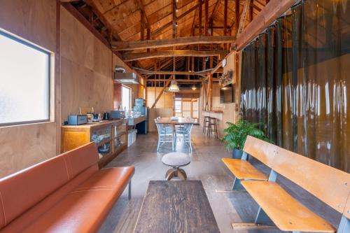a room with benches and a table and a kitchen at 波と月 in Oarai