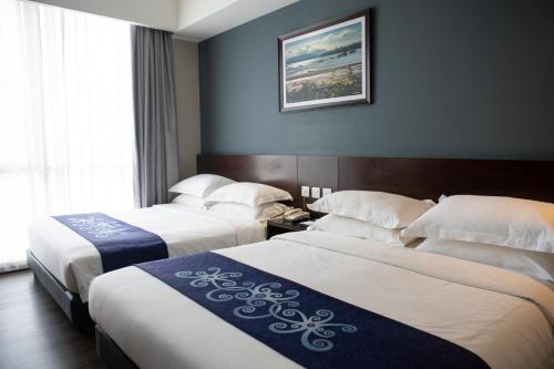 a hotel room with two beds and a picture on the wall at Meritin Hotel in Kuching