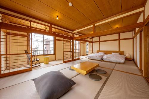 a room with two beds and a table and windows at 波と月 in Oarai