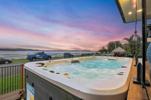 a hot tub on a balcony with a view of the ocean at Marea at Tanilba Bay in Lemon Tree Passage