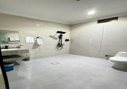 a white bathroom with a toilet and a sink at زون آفينيو للشقق المخدومة Zone avenue in Hafr Al-Batin