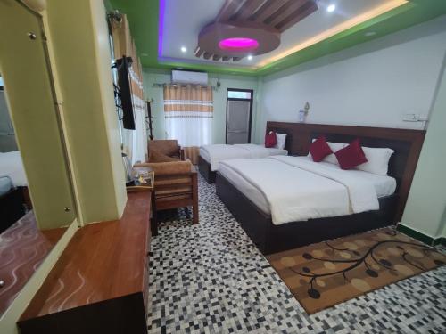 a hotel room with two beds and a chair at River Side Hotel Pvt Ltd in Tanahun