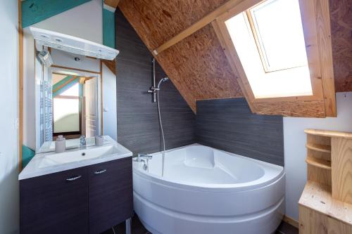 a bathroom with a large tub and a sink at Chalet avec jardin et vue 6 personnes in Espezel
