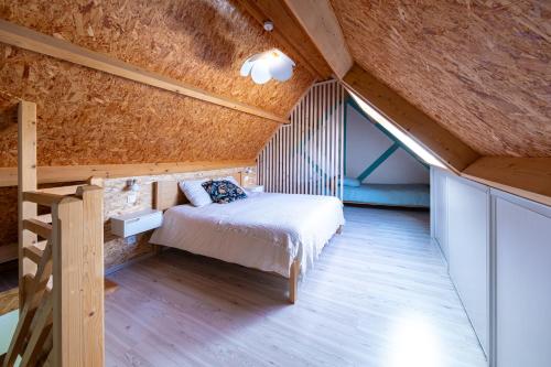 an attic bedroom with a bed and a ladder at Chalet avec jardin et vue 6 personnes in Espezel