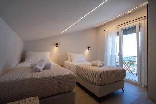 zwei Betten in einem Zimmer mit Balkon in der Unterkunft ERA Suites in Stomio