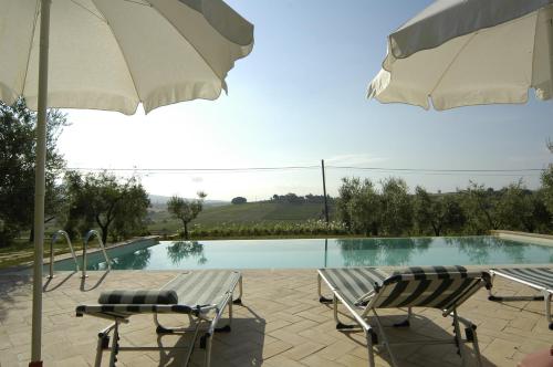 two chairs and an umbrella next to a swimming pool at Agriturismo Spazzavento in Vinci