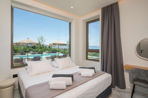 a bedroom with a bed and a large window at Infinite View Villa in Platanias