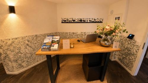 a table in a room with a laptop on it at Hotel Sternen Gurtnellen AG in Gurtnellen