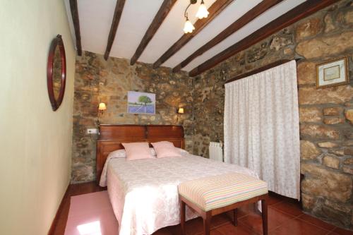 a bedroom with a bed and a stone wall at La Llosa II in Villaviciosa