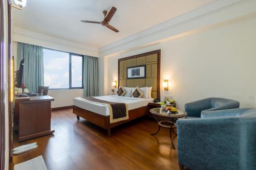 a hotel room with a bed and a couch at Foxoso The BMK - A Corporate Hotel in New Delhi