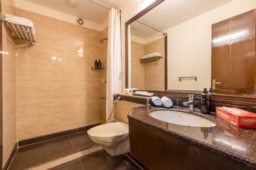 a bathroom with a toilet and a sink at Foxoso The BMK - A Corporate Hotel in New Delhi