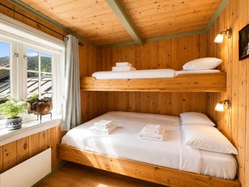 two bunk beds in a wooden room with a window at Hallingstue by Hallstensgaard - Geilo in Geilo