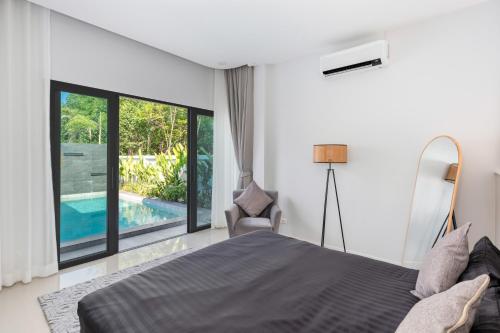 a bedroom with a bed and a large window at Harmony Pool Villa Ao Nang in Ao Nang 