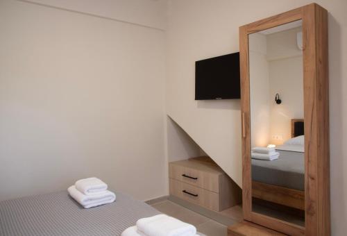 a bedroom with a mirror and a bed and a tv at Virea VA Complex in Vaia