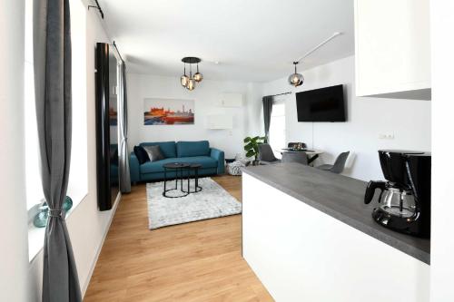 a kitchen and living room with a blue couch at Apartment Schweriner Lieblingsplatz in Schwerin
