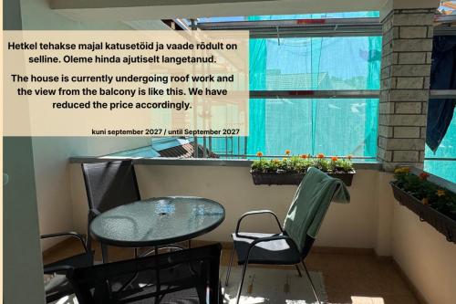 a table and chairs in a room with a window at Maria Apartment Tolli põik in Kuressaare