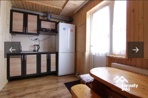 a kitchen with a refrigerator and a table in a room at Микуличин на долоні 2 in Mykulychyn
