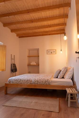a large bed in a room with wooden ceilings at um pouco de campo in Torres Vedras