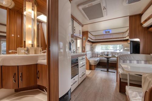 a kitchen and dining area of an rv at Kemping Molo Surf by Q4Camp in Jastarnia