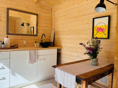 a kitchen with wooden walls and a wooden table and a sink at Haapsi Hideaway Garden Cabin in Haapsi