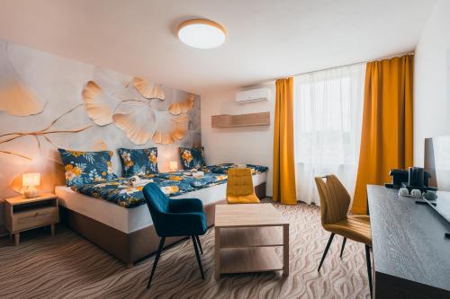 a bedroom with a bed and a desk and chairs at Hotel Mauricius in Příbram