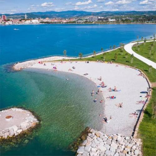 a group of people on a beach in the water at Athena in Koper
