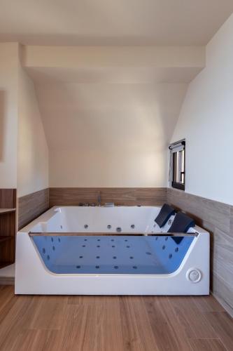 a large bath tub in a room with a wooden floor at TAYS Hotel in Kalamata