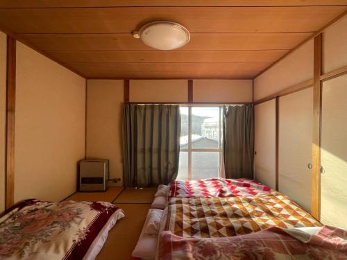 a bedroom with a bed and a window at Mizubaso in Gujo