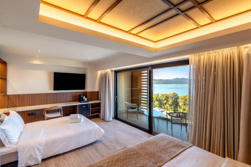 a bedroom with a bed and a balcony with a view at TAYS Hotel in Kalamata