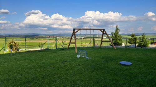 an empty swing set in a field with a frisbee at Červene maky - red poppies in Malý Slavkov