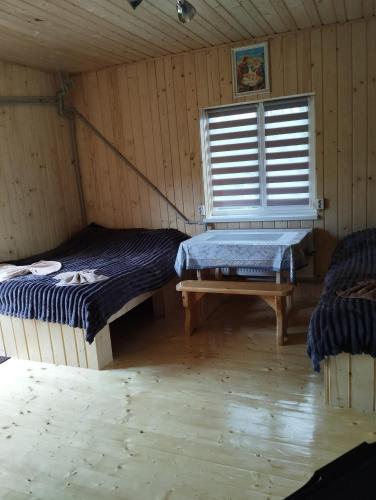a room with two beds and a window in it at Вершина спокою in Mykulychyn