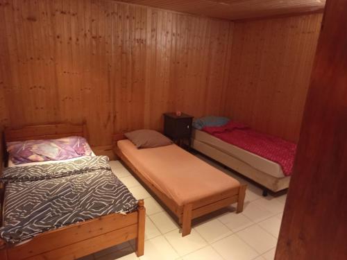 three beds in a room with wooden walls at Huis bij basel in Hésingue