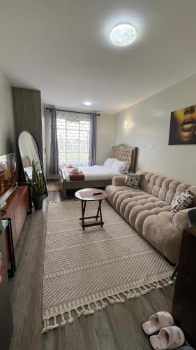 a large living room with a couch and a table at Amber Home Ruaka Near Two Rivers Mall & UN in Ruaka