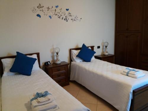 ヴィチェンツァにあるAppartamento Acero Rossoの青い枕が備わる客室内のベッド2台