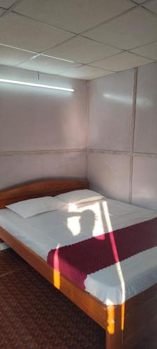 a bed in a small room with a spotlight on it at ChangGhor in Digru