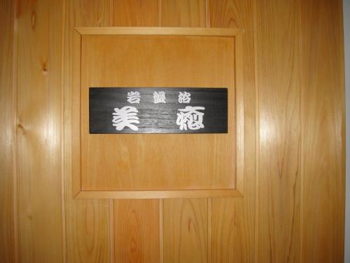 a sign on a wooden door with writing on it at Otowaya Ryokan in Yuzawa