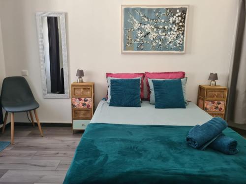 a bedroom with a bed with blue and red pillows at CURIAL INSOLITE - Annecy à 30 min in Chambéry