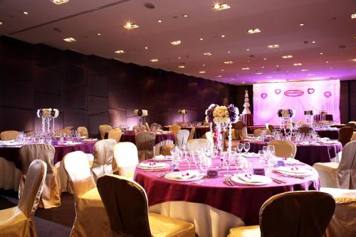 a room with tables and chairs with purple and white table settings at Jianguo Hotel Guangzhou in Guangzhou