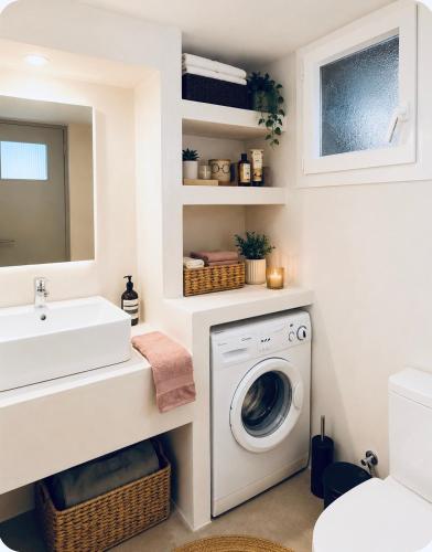 a bathroom with a washing machine and a sink at Seafront Central Luxury Apartment in Samos