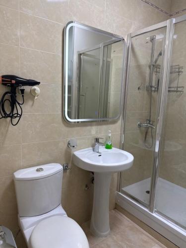 a bathroom with a toilet and a sink and a shower at Иссык-Куль,Частный таунхаус-всего минута до пляжа в ЦО "Karven Four Seasons" Issyk-Kul in Chon-Sary-Oy