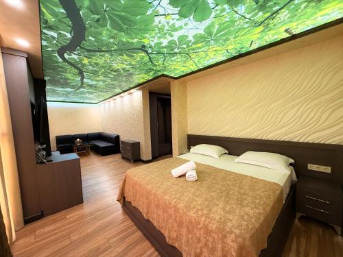 a bedroom with a bed with a painting on the wall at Israel Ori Hotel in Yerevan
