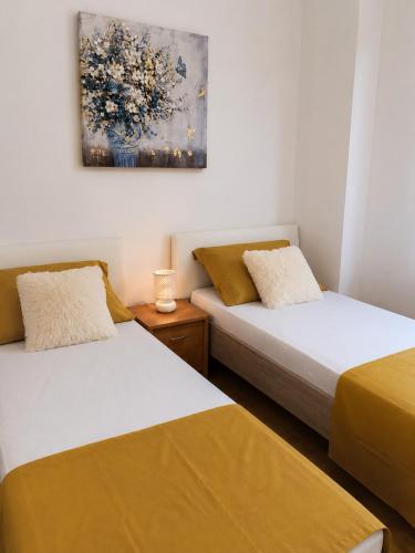 two beds in a room with a painting on the wall at Apartment Ivan in Marina